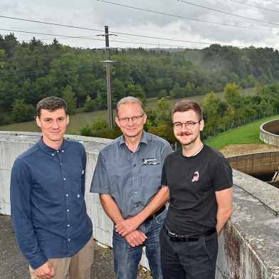 Three environmental engineers in front of wastewater treatment plant