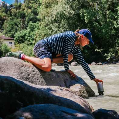 Woman takes water samples from the river