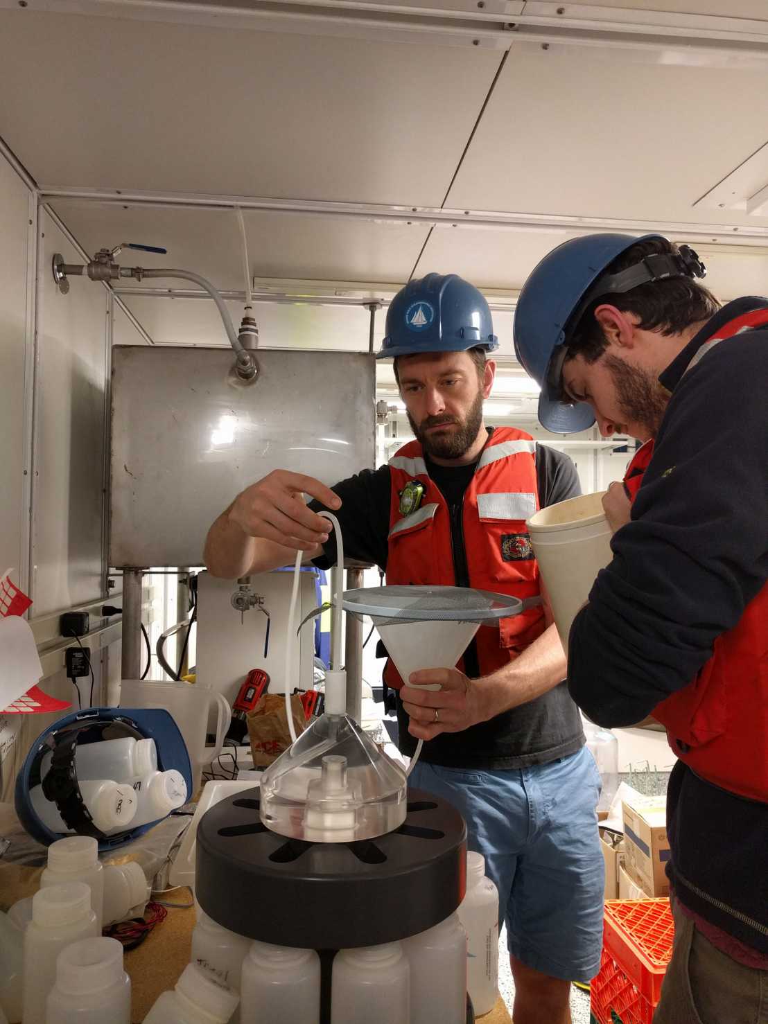 Two men handling lab equipment