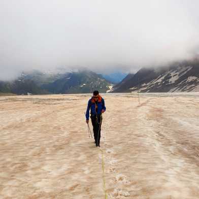 A man walking over a glacier