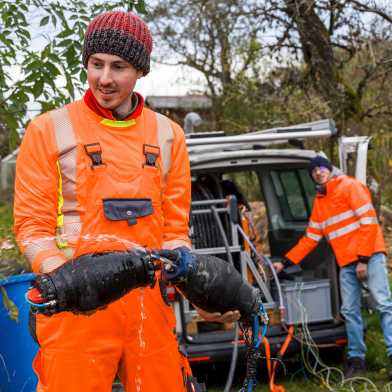 Man in orange overall holds the two sealing elements in his hand