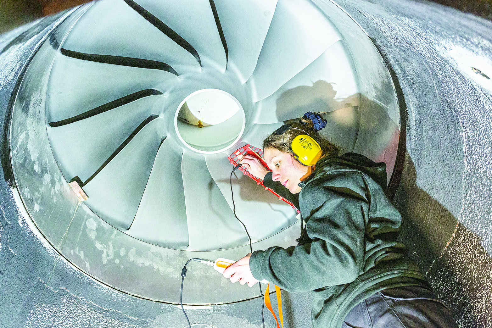 woman measures coating thickness on turbine