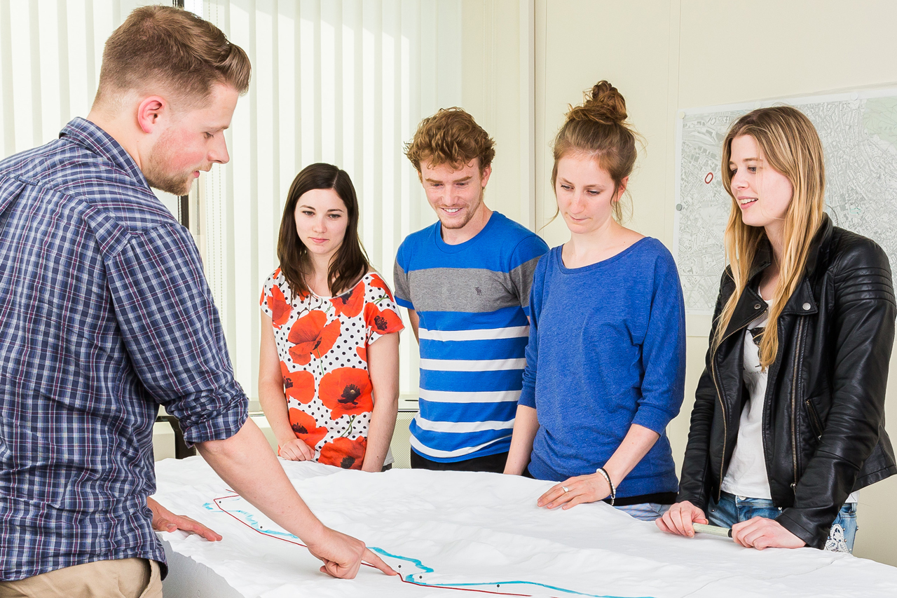 An assistant explains four students based on a model of the Limmat Valley the importance of foresight planning (© Timon Furrer, ETH Zürich)