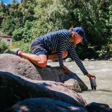 Frau nimmt Wasserproben aus dem Fluss