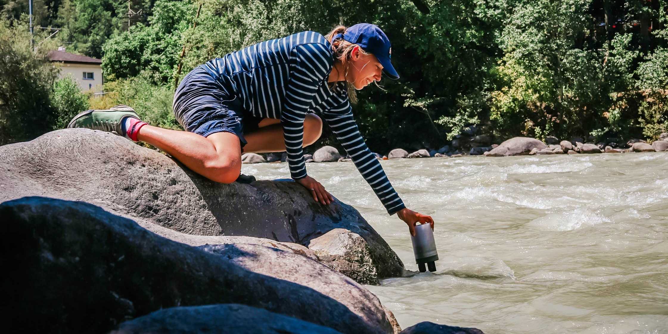 Frau nimmt Wasserproben aus dem Fluss