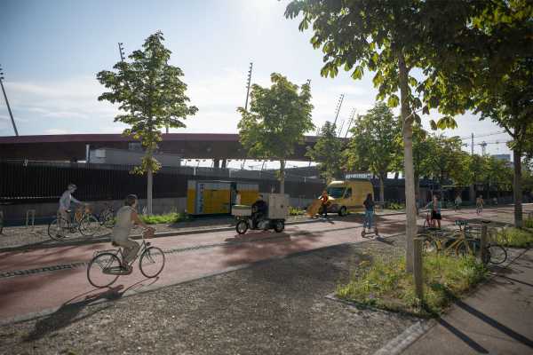 Vergrösserte Ansicht: Im Hintergrund steht das Letzigrund Stadion. Davor ist ein Velostreifen mit mehreren Fahrrädern darauf sichtbar. Dieser ist von der Strasse abgetrennt.